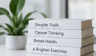 A stack of books titled Simpler Tools, Clearer Thinking, Better Habits and A Brighter Everyday beside a plant.